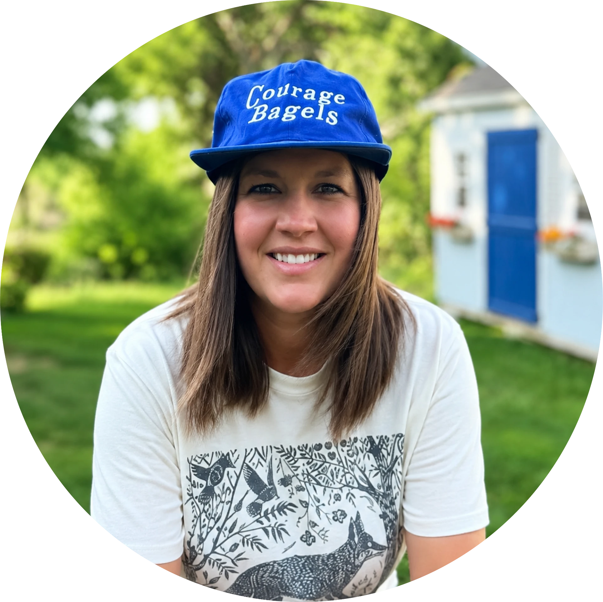 Jennifer Woockman smiling outdoors in a blue Courage Bagels cap